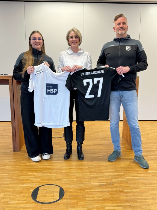 Team hält Trikot hoch